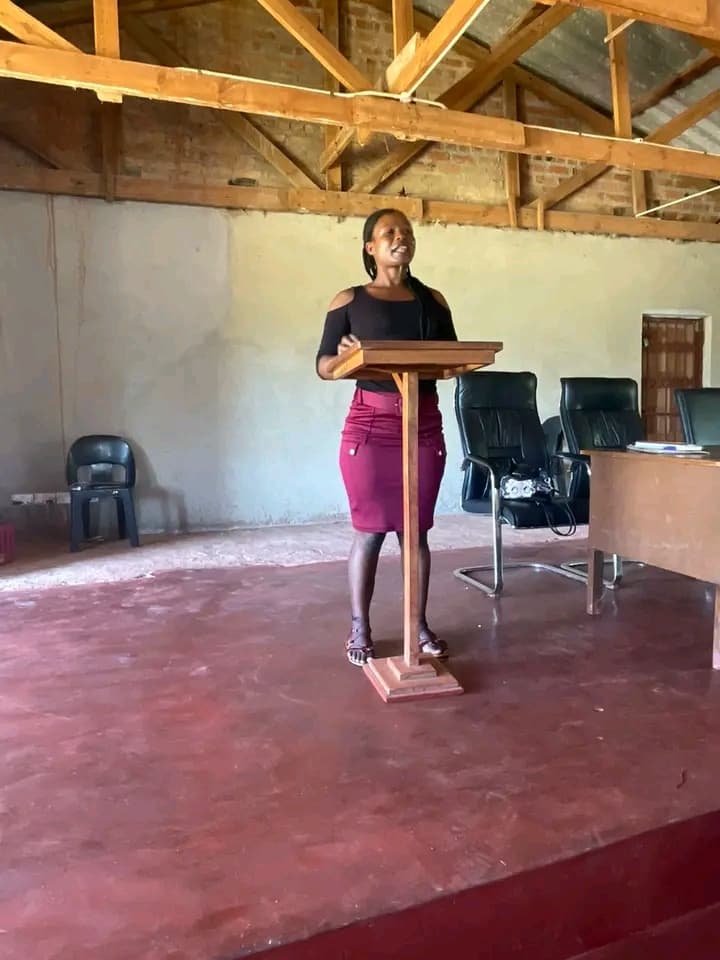 Young woman delivering remarks at a community hall