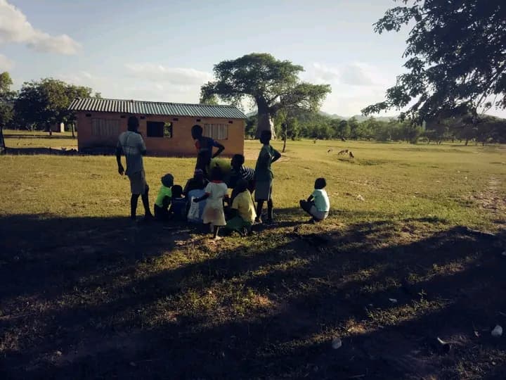 Children gathered outside a rural school at golden hour